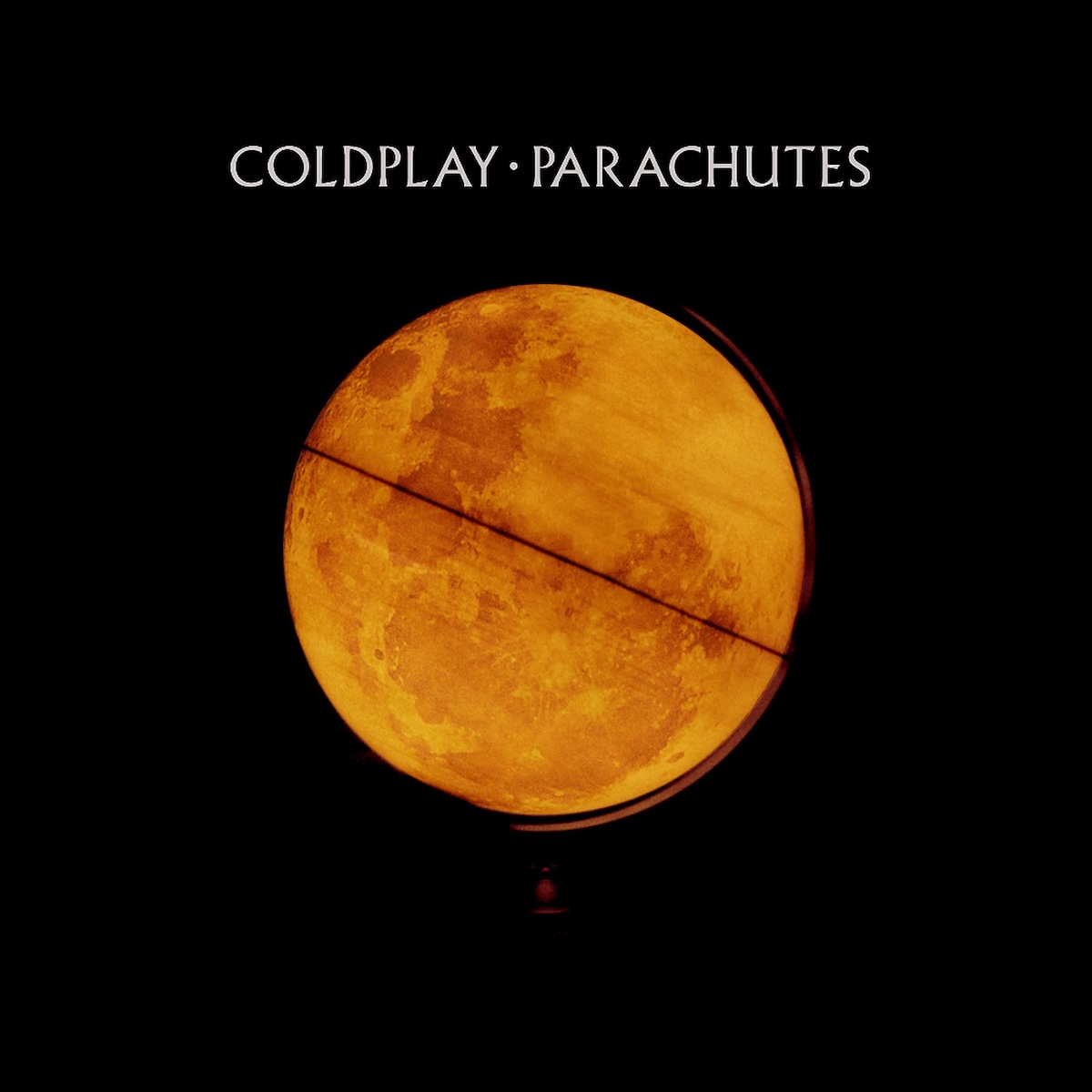 Album Art of Coldplay's Parachutes album - A photo of a globe of the earth that is an orange color that is spinning rapidly and lit from inside of the globe, such that a bit of the stand of the globe is softly lit, but the rest of the room is black. Above the globe in the blackness is printed in gray letters the band name and the album name.