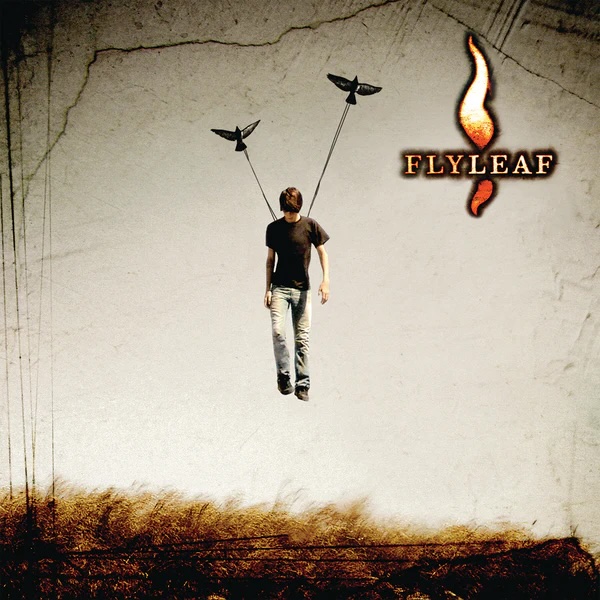 Album Art of Flyleaf's self-titled album - Above some long, brown grasses as the bottom, a man is suspended in the air from the shoulders, it looks like, by two birds with strings hanging down to the person. The young man is looking down at the ground. In the top right, the band's name is printed in golden orange hues, with one golden orange flame extending above and below the band name.