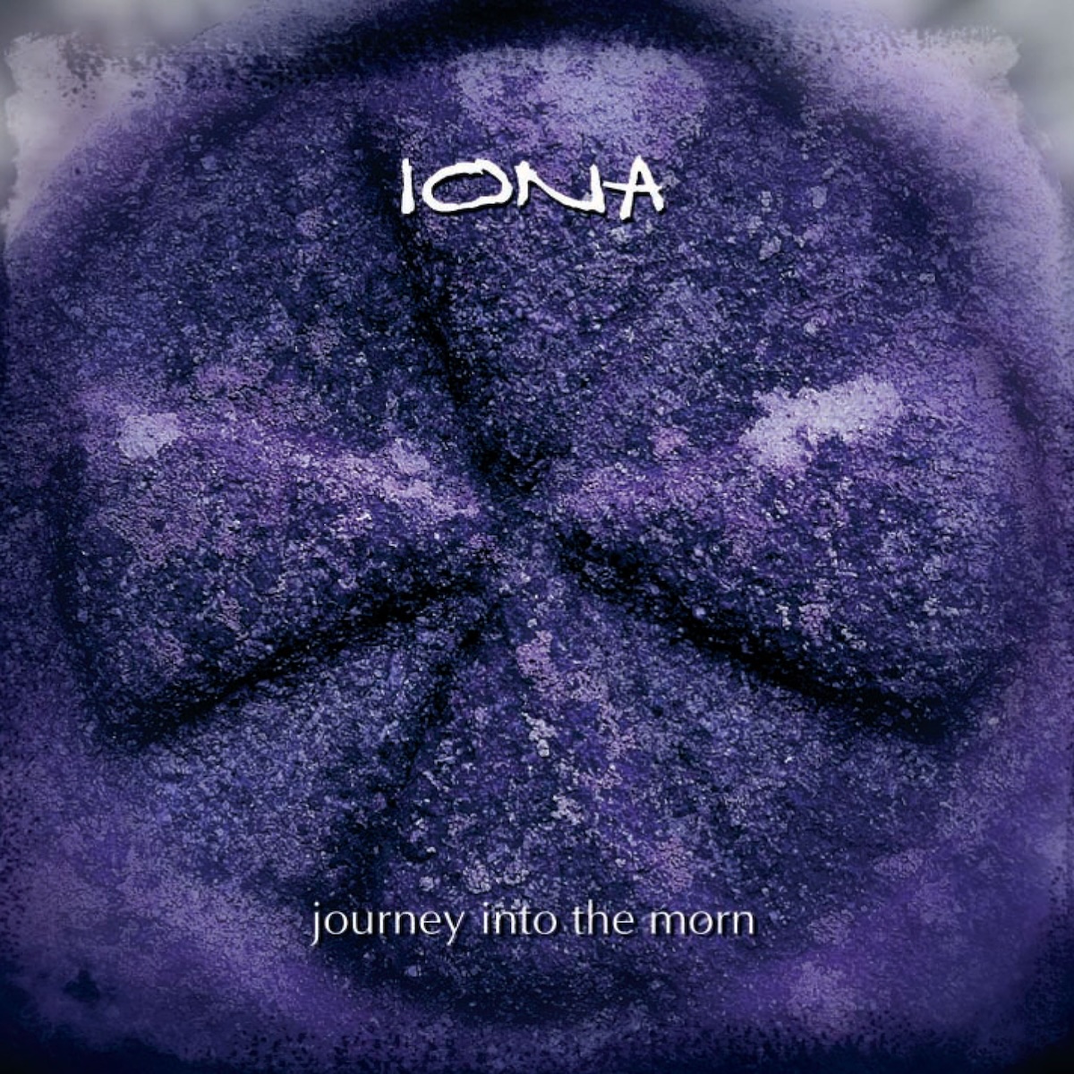 Album Art of Iona's Journey Into The Morn album re-release - A photo of an ancient stone cross through a circular portal of some sort. The edges of the portal are blurry, and the color of the stone seems to be shades of purple somehow. Printed on top of the photo in the center towards the top is the band's name in a white, handwritten-style font, their normal word mark. And printed at the bottom middle is the album title in a sans-serif font, thin and white, all in lowercase.