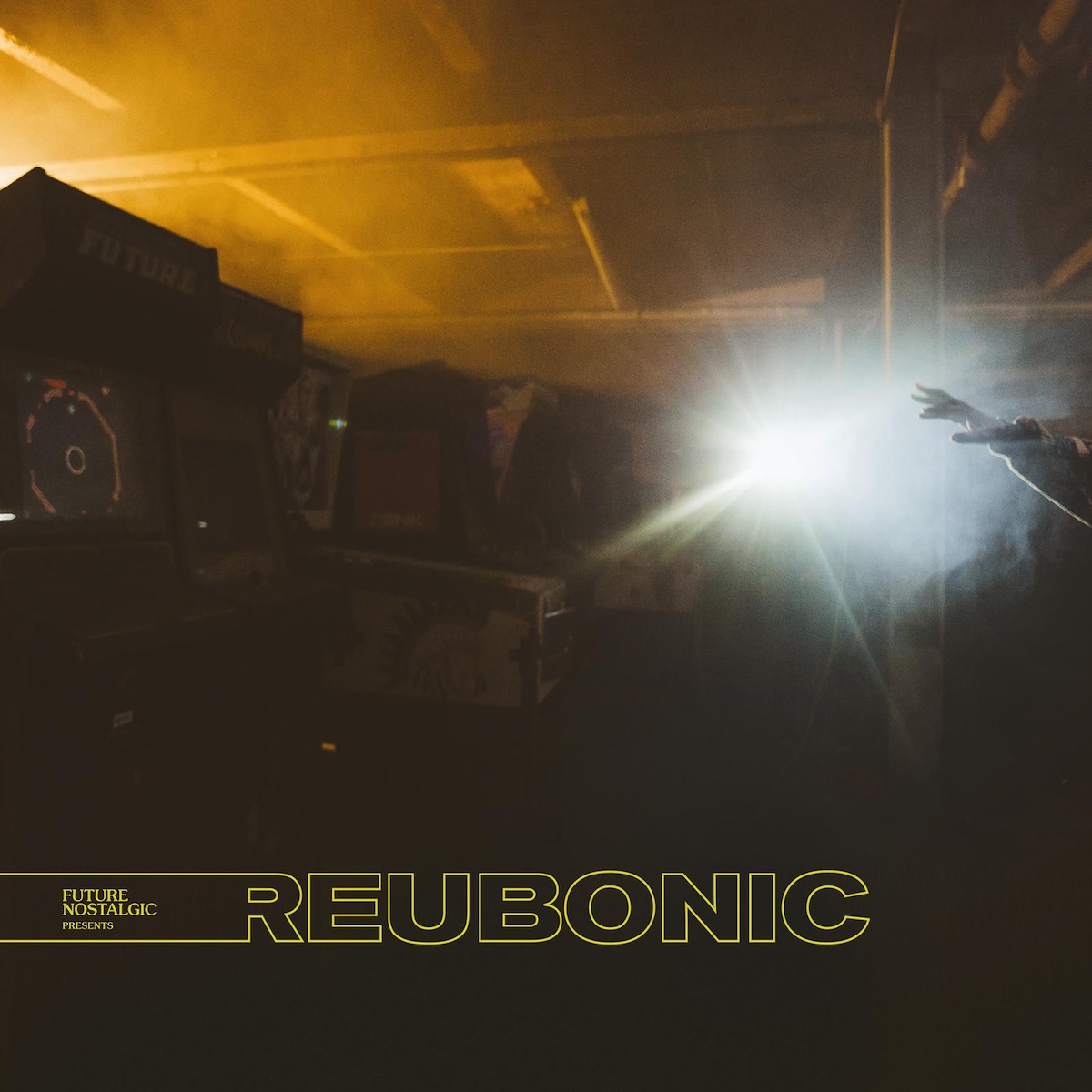 Album Art of John Reuben's Reubonic album - A photo that seems to be a large, low-ceilinged room with turned off pinball machines and arcade cabinets to the left in the dark, though there's an orange glow coming from above and behind them. On the right, a bright white light is overpowering everything else, except to the far right, one hand is in front of the light reaching out. In the blackness at the bottom is printed the album title in a yellow outline.</body></html>