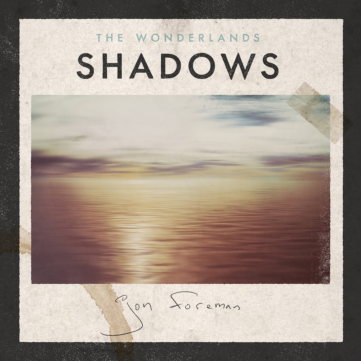 Shadows EP - On what looks like rough, light brown paper with a coffee cup stain in the bottom left, there is a photo of a cloudy sky with a sunset behind the clouds over a calm, wide body of water. On the right edge, the image is worn out a bit, and there's a piece of clear tape on the top right of the image, affixing it to the paper. Above it, in the middle, it says 'The Wonderlands' in a smaller, light gray font, and 'Shadows' in a much larger black text. Below the photo, there's a handwritten, thin pen signature of Jon Foreman. There's also a thick black border around it.