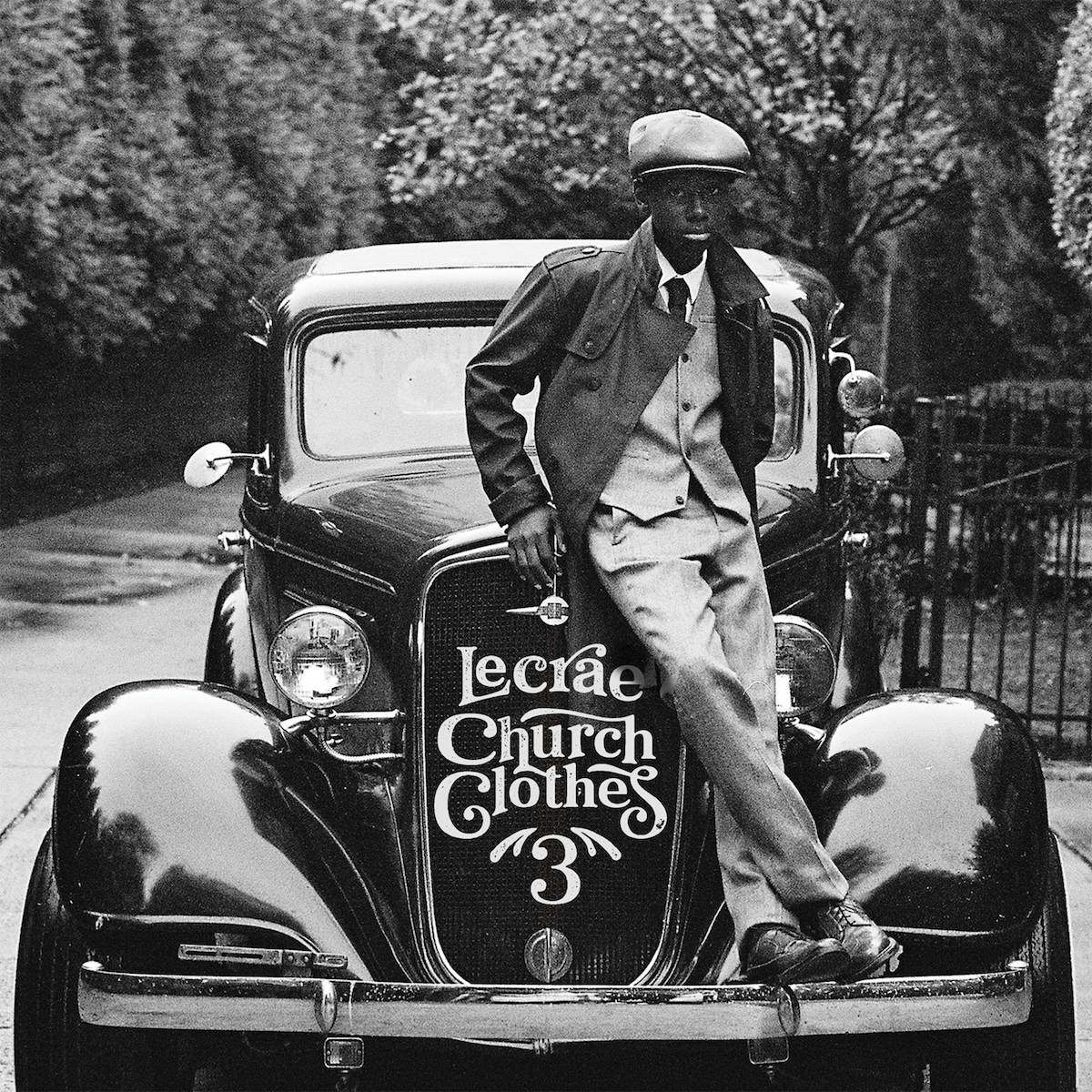 Album Art of Lecrae's Church Clothes 3 album - A black and white photo of a black kid standing on the front of a vintage, early 1900s car's bumper and sitting on the edge of the hood. He's also in a vintage coat with a vest and pants of a lighter shade and a white shirt and dark tie underneath. The car is sitting on cement near a wrought-iron fence and there's trees in the background.</body></html>