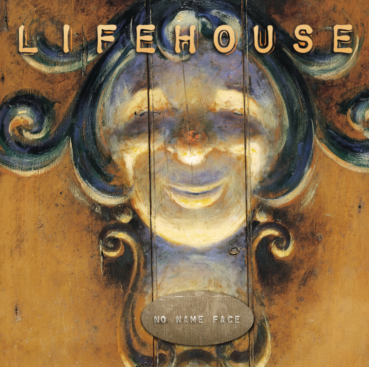 Album Art of Lifehouse's No Name Face album - A painting or a photo of a painted face, maybe found on some sort of carnival ride or something. The face is round and white and there's green/black curls on the top and sides that kinda look like hair, and also look like decorative, curly edges to an ornate design. Below the face is a plaque that has the album title stamped on it in small, uppercase print. Across the top the band's name is printed in golden orange in a boxy font with some more golden edging making a rough drop shadow.