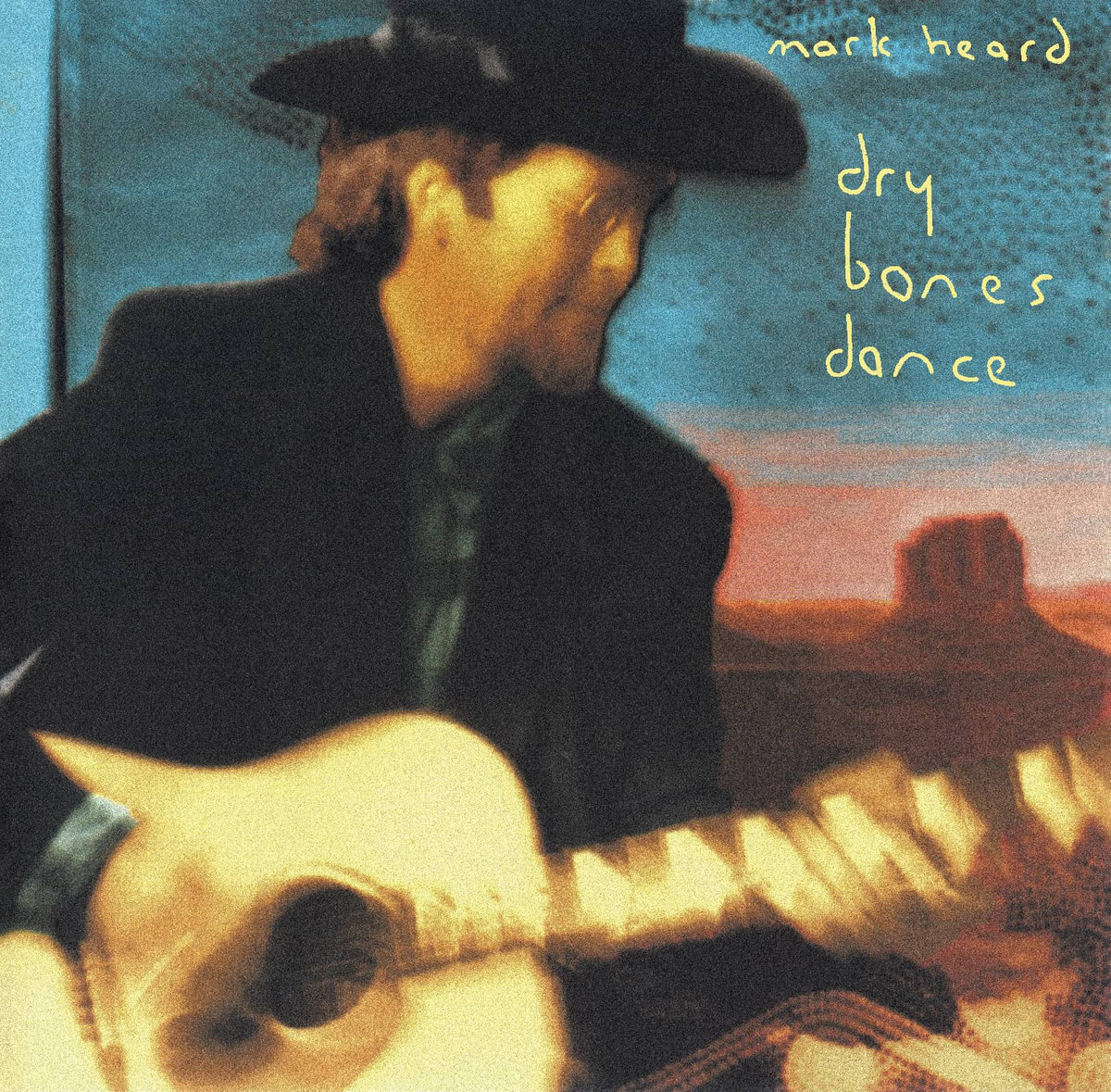 Album Art of Mark Heard's Dry Bones Dance album - A man in a black cowboy hat and a black jacket is on the left side, playing a guitar. The man is in motion so the photo of him is a bit blurry, He has a brown beard and long brown hair and small circular, wire-rimmed glasses on his nose. Behind him can be seen a blue sky and a landscape of the western US, maybe Devil's Tower being visible off to the right over the top of his guitar neck.</body></html>