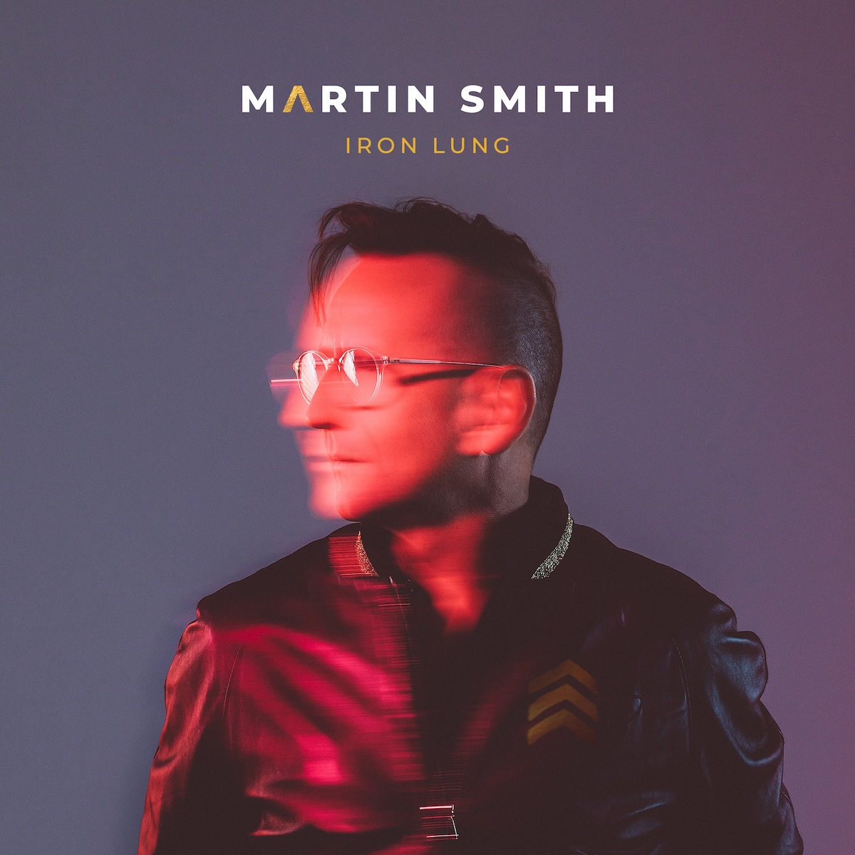 Album Art of Martin Smith's Iron Lung album - On a purple-gray background, a photo of a white man in a black leather jacket lit by some red light. He has very short hair on the sides, a bit longer on top, and some circular glasses. The person seems to have been moving, because it's a very blurry photo in spots, like he was moving is head and jacket while he was being photographed.</body></html>