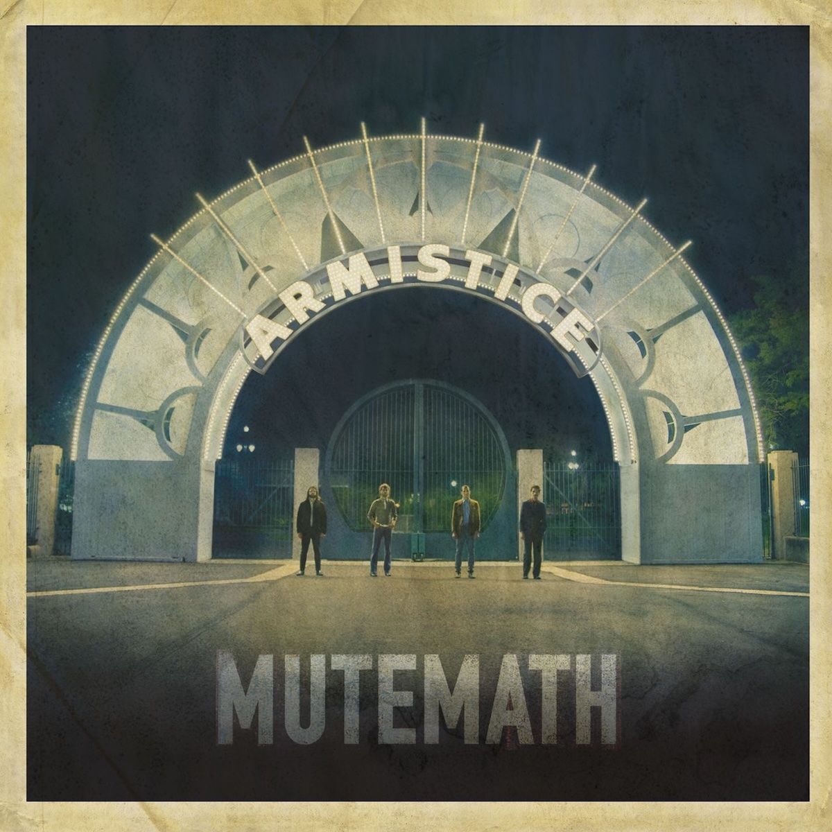 Album Art of Mutemath's Armistice album - A photo of four people on a dark night standing in front of a gate, shot from fairly far back. They are standing 2-3 feet away from each other in a line in front of the gate, and the gate has a large circular arch with a geometric design in mostly white and green on it. The arch also seems to have lights on it and the arch and the ground in front of it is well-lit.</body></html>