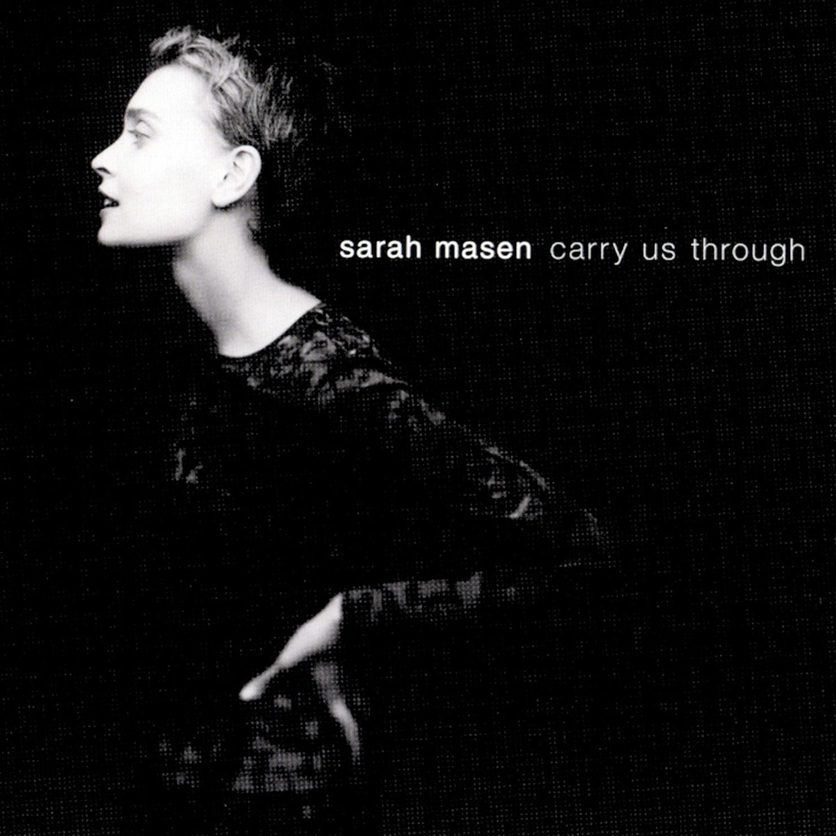 Album Art of Sarah Masen's Carry Us Through album - On a black background, a black-and-white photo of a woman in a black shirt with a dark grey or iridescent print on it is photographed in profile, with her facing to the left of the frame. Most of the light is coming from the direction of the camera, so the features of the white woman with short hair really pops from the black background and the black shirt. To the right of her, at about the level of her neck, is the artist name in bold white text and the album name to the right of that in thinner white text.