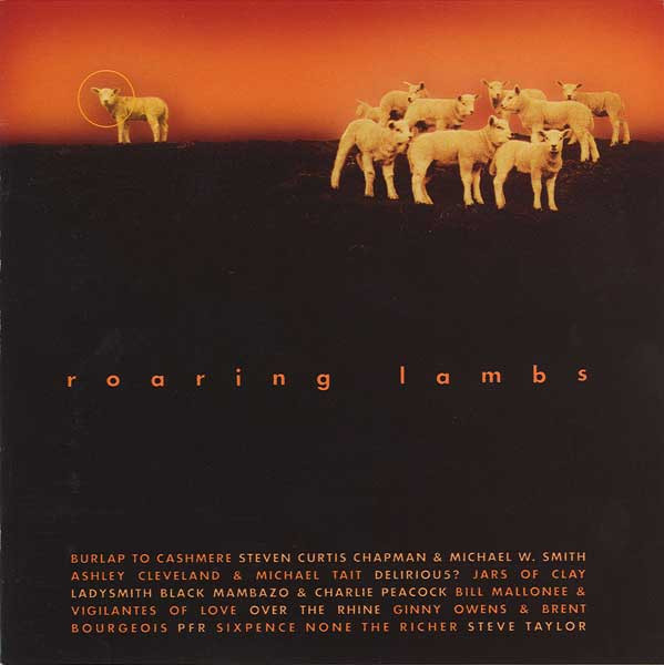 Album Art of Various Artists album titled Roaring Lambs - On a dark brown, nearly black background taking up the bottom four fifths, is the title of the album in the middle and a block of all the artists and bands involved at the bottom. In the top quarter, on the right there's a photo of a group of about 10 lambs on the right, and one lamb on the left with an orange circle printed around its head. Just above where the lambs are standing is an orange gradient, some sort of sky, assumingly.